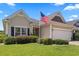 Well-maintained home with an attached two-car garage, complemented by lush landscaping and an American flag at 155 Palmetto Green Dr., Longs, SC 29568