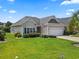 Charming single-story home with well-maintained lawn, attached garage, and manicured landscaping at 155 Palmetto Green Dr., Longs, SC 29568