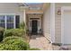 Inviting covered front porch with seating area and well-maintained landscaping, leading to the main entrance at 155 Palmetto Green Dr., Longs, SC 29568