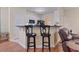 Open concept kitchen bar featuring white cabinets and two black bar stools at 155 Palmetto Green Dr., Longs, SC 29568