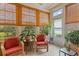 Relaxing sun room with tiled floors, multiple windows, and comfortable furniture at 155 Palmetto Green Dr., Longs, SC 29568
