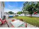 Large backyard with a brick patio, a table with chairs, and a spacious lawn at 180 Weeping Willow Dr., Myrtle Beach, SC 29579