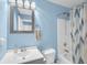 Cozy bathroom featuring light blue walls, a shower-tub combo and a decorative mirror at 180 Weeping Willow Dr., Myrtle Beach, SC 29579