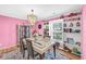 Bright dining room featuring pink walls, an elegant chandelier, and built-in shelving at 180 Weeping Willow Dr., Myrtle Beach, SC 29579
