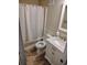 Cozy bathroom featuring a shower with curtain, toilet, and vanity with white marble top and cabinet at 1919 Spring St. # B12, North Myrtle Beach, SC 29582