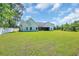 Expansive backyard featuring a white home with a dark roof, surrounded by lush green lawn and trees at 2192 Eastwoods Dr., Conway, SC 29526