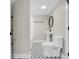 Well-lit bathroom featuring a pedestal sink, round mirror and black and white mosaic tile flooring at 2192 Eastwoods Dr., Conway, SC 29526