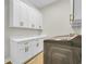 Bright laundry room features white cabinetry, modern hardware, and a stainless steel washer and dryer at 2192 Eastwoods Dr., Conway, SC 29526