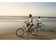 Couple enjoying a leisurely bike ride along the beach; a great way to experience the ocean and scenic views at 222 Atlantic Breeze St., Myrtle Beach, SC 29572