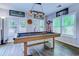 Bright game room featuring a wood pool table, plantation shutters, and overhead lighting at 2479 Burning Tree Ln., Little River, SC 29566