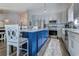 Bright kitchen with stainless steel appliances, gray cabinets, a blue island with seating, and hardwood floors at 2479 Burning Tree Ln., Little River, SC 29566