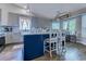 Well-lit kitchen features gray cabinets, stainless steel appliances, and a kitchen island with barstool seating at 2479 Burning Tree Ln., Little River, SC 29566