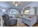 Comfortable living room features a ceiling fan, neutral paint, and a large TV with an entertainment center at 2479 Burning Tree Ln., Little River, SC 29566