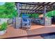 Outdoor kitchen featuring bar seating, stone accents, overhead lighting, and a mounted tv at 2479 Burning Tree Ln., Little River, SC 29566