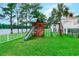 Playground with a slide, swings, and a grass lawn, located near a pond at 2479 Burning Tree Ln., Little River, SC 29566