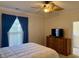 Comfortable bedroom with a ceiling fan, window, and a wooden dresser with a flat screen television at 312 Shelly Bay Ct., Surfside Beach, SC 29575