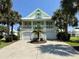 Charming two-story home with a light green exterior, white trim, a spacious balcony and a two-car garage at 312 Shelly Bay Ct., Surfside Beach, SC 29575