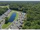 Golf course community featuring a pond, swimming pool, and townhomes nestled among mature trees at 315 Bulkhead Bend # 315, Carolina Shores, NC 28467