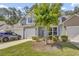 Charming two-story home featuring a garage, blue shutters, and a well-manicured lawn with a beautiful flowering tree at 315 Bulkhead Bend # 315, Carolina Shores, NC 28467
