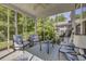 Screened patio with cozy seating and views of a wooded backyard at 315 Bulkhead Bend # 315, Carolina Shores, NC 28467