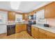 Galley-style kitchen has wood cabinets, granite countertops, black appliances and hardwood floors at 329 54Th Ave. N, North Myrtle Beach, SC 29582