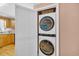 Laundry closet with stacked front-loading washer and dryer, with kitchen viewable to the side at 329 54Th Ave. N, North Myrtle Beach, SC 29582