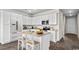 Bright kitchen features white cabinetry, stainless appliances, and a cozy center island with seating at 3382 Wood Stork Dr., Ocean Isle Beach, SC 28469