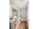 Bathroom features a double vanity with framed mirror and updated fixtures plus wood look floors at 409 Cypress View Ave., Little River, SC 29566