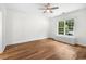 Bright bedroom featuring wood floors, a ceiling fan, and a window seat with built-in storage at 409 Cypress View Ave., Little River, SC 29566