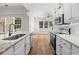 Well-lit kitchen with granite counters, stainless appliances, and wood floors at 409 Cypress View Ave., Little River, SC 29566