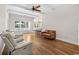 Bright living room with ceiling fan, hardwood floors, and an open layout with views of the kitchen and pool at 409 Cypress View Ave., Little River, SC 29566