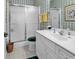 Bathroom with tiled walls, a single sink vanity, frosted glass shower doors and a patterned floor at 4400 Turtle Ln. # 2-D, Little River, SC 29566