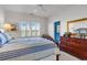 A bright main bedroom featuring a bed with blue linens, and a dresser with a view to the water at 4400 Turtle Ln. # 2-D, Little River, SC 29566