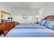 A bright main bedroom featuring a bed with blue linens, a dresser, and ensuite bathroom access at 4400 Turtle Ln. # 2-D, Little River, SC 29566