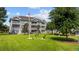 Condominium exterior with lush green lawn, flag pole, benches, and grilling area at 4683 Wild Iris Dr. # 103, Myrtle Beach, SC 29577