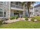 Exterior view of condo with lush landscaped patio, white railings, and brick accents at 4683 Wild Iris Dr. # 103, Myrtle Beach, SC 29577