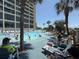 View of a long pool surrounded by people and lounge chairs and the resort building in the background at 4800 S Ocean Blvd. # 706, North Myrtle Beach, SC 29582