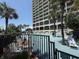View of the pool area with people and the resort building. There is a sign that says, 'No glass is allowed on pool deck' at 4800 S Ocean Blvd. # 706, North Myrtle Beach, SC 29582