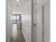 A bright hallway leads to a kitchen with a balcony, featuring wainscoting and wood floors at 5523 N Ocean Blvd. # 1412, Myrtle Beach, SC 29577