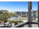 A cozy, covered balcony overlooks a community swimming pool surrounded by lush tropical landscaping at 6001 N Ocean Blvd. # 137, North Myrtle Beach, SC 29582
