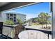 View from the balcony showcasing the outdoor furniture and community buildings in the distance, framed by a clear blue sky at 6001 N Ocean Blvd. # 137, North Myrtle Beach, SC 29582