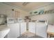 Bright laundry room featuring multiple washers and dryers, clean surfaces, and decorative shelving and artwork at 6001 N Ocean Blvd. # 137, North Myrtle Beach, SC 29582