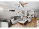 Comfortable living room with wood floors, gray sofa, TV, and partial view of kitchen at 6001 N Ocean Blvd. # 137, North Myrtle Beach, SC 29582