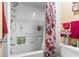 Clean bathroom bathtub with white showerhead and storage; a floral curtain adding color at 6804 North Ocean Blvd. # 515, Myrtle Beach, SC 29572