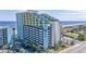 Beautiful full exterior of oceanfront resort featuring a view of the beach and large parking area at 6804 North Ocean Blvd. # 515, Myrtle Beach, SC 29572