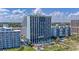 Exterior view of a high-rise building next to a pool and green lawn with umbrellas and palms at 6804 North Ocean Blvd. # 515, Myrtle Beach, SC 29572
