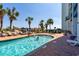 Outdoor pool and hot tub surrounded by red brick patio, palm trees, and a playground at 6804 North Ocean Blvd. # 515, Myrtle Beach, SC 29572