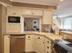 Bright kitchen with white cabinets, tile backsplash and countertops, and modern stainless steel appliances at 701 Norris Dr., Pawleys Island, SC 29585