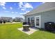 Cozy backyard patio with a fire pit, seating, grill, and a view of the well-maintained lawn and neighborhood at 715 Hobonny Loop, Longs, SC 29568