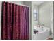 Neutral bathroom featuring a separate tub and shower with a patterned shower curtain and a large window at 715 Hobonny Loop, Longs, SC 29568